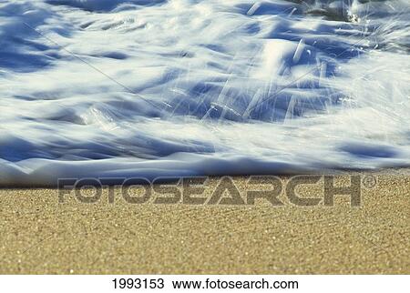 Stock Image - Hawaii, Ripple Of Water And Seafoam Breaks On Sandy Shore.. Fotosearch