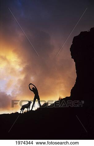 Picture - Hawaii, Silhouette Of A Woman Stretching On A Mountain Top At Sunset.. Fotosearch