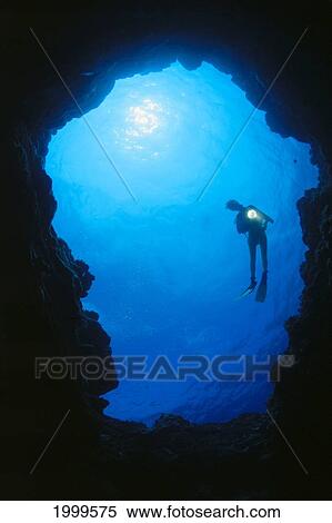Stock Photography - Hawaii, Silhouetted Diver At Cavern Entrance With Flashlight, Sunburst. Fotosearch