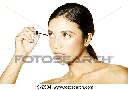 Hawaii, Studio Headshot Of A Beautiful Girl Putting On Mascara. View Large Photo Image Picture - Hawaii, Studio Headshot Of A Beautiful Girl Putting On Mascara.. Fotosearch