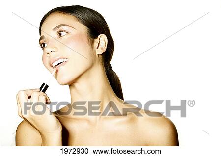 Hawaii, Studio Headshot Of A Beautiful Girl Putting On Lipstick. View Large Photo Image Stock Image - Hawaii, Studio Headshot Of A Beautiful Girl Putting On Lipstick.. Fotosearch