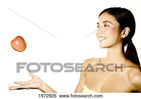 Stock Photograph - Hawaii, Studio Headshot Of A Beautiful Girl Holding An Apple.. Fotosearch