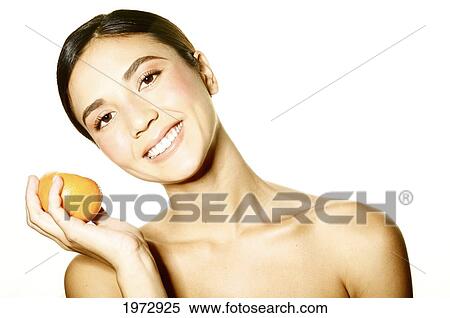 Stock Photography - Hawaii, Studio Headshot Of A Beautiful Girl Holding An Orange.. Fotosearch