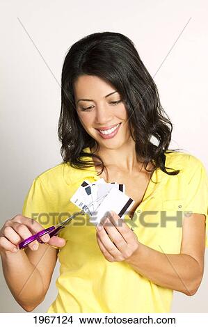 Picture - Hawaii, Studio Shot Of Woman Cutting Up Credit Cards.. Fotosearch
