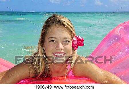 Stock Photo - Hawaii, Teenage Girl In Ocean With Inflatable.. Fotosearch