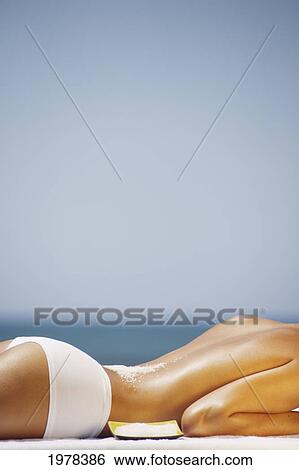 Stock Photograph - Hawaii, Torso Of A Girl Laying Down Next To Ocean On Massage Table, Seasalt Sprinkled On Her Back.. Fotosearch