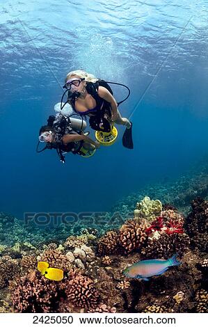 Hawaii, Two young women on underwater scooters, Colorful reef scene in foreground. View Large Photo Image Stock Image - Hawaii, Two young women on underwater scooters, Colorful reef scene in foreground.. Fotosearch
