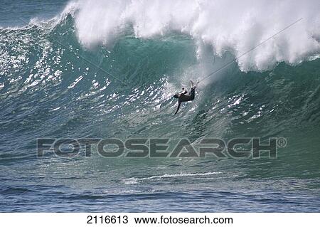 Stock Image - Hawaii, Waimea Bay, man surfing a large wave.. Fotosearch