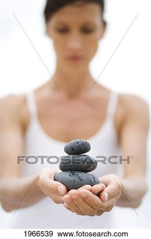 Stock Photo - Hawaii, Woman Holding Stack Of Stones In Hands.. Fotosearch