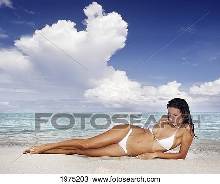 Stock Image - Hawaii, Woman Laying On The Beach In Remote Tropical Location.. Fotosearch