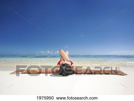Stock Image - Hawaii, Woman Laying On The Beach In Remote Tropical Location.. Fotosearch