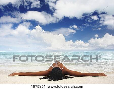 Stock Image - Hawaii, Woman Laying On The Beach In Remote Tropical Location.. Fotosearch
