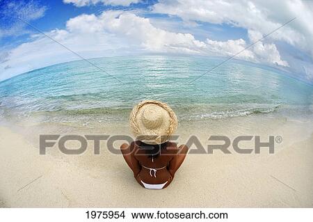 Picture - Hawaii, Woman Sitting On Beach In Remote Tropical Location.. Fotosearch