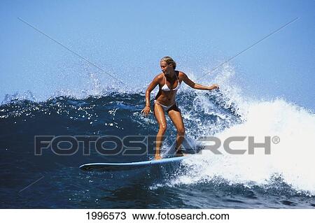 Stock Image - Hawaii, Young Caucasian Woman Surfing Wave. Fotosearch