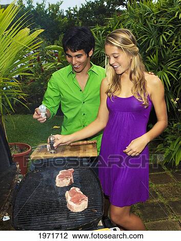 Stock Image - Hawaii, Young Couple Having Outdoor Barbecue In Tropical Garden.. Fotosearch