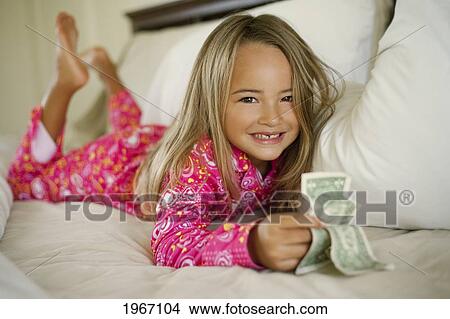 Picture - Hawaii, Young Girl Collecting Tooth Fairy Money From Under Pillow.. Fotosearch