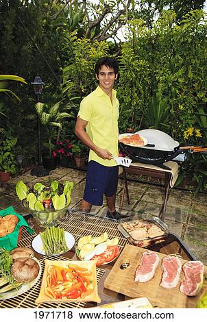 Hawaii, Young Man Preparing Outdoor Barbecue Feast In Hawaii Garden. View Large Photo Image Stock Photo - Hawaii, Young Man Preparing Outdoor Barbecue Feast In Hawaii Garden.. Fotosearch