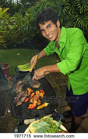 Hawaii, Young Man Preparing Outdoor Barbecue Feast In Hawaii Garden. View Large Photo Image Stock Photography - Hawaii, Young Man Preparing Outdoor Barbecue Feast In Hawaii Garden.. Fotosearch