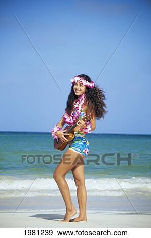 Stock Photo - Hawaiian Girl Playing Ukulele On White Sand Beach Near Ocean Shoreline.. Fotosearch