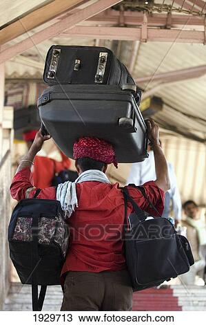 Stock Image - Head-loading porter carrying luggage at Jaipur Junction train station in Jaipur, capital of Rajasthan, India. March. ÃƒÆ’Ã…Â Asia. ÃƒÆ’Ã…Â . Fotosearch