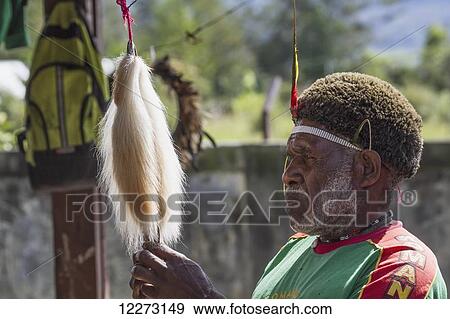 Stock Photo - Headdress vendor at the market, Wamena, Papua, Indonesia. Fotosearch
