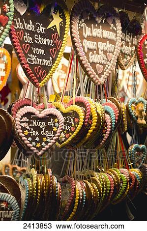 Stock Image - Heart shaped decorative cookies hanging on display with written verses; Munich, Germany. Fotosearch