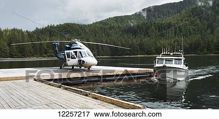 Helicopter on a dock alongside a fishing boat; Queen Charlotte Islands, British Columbia, Canada View Large Photo Image Stock Photo - Helicopter on a dock alongside a fishing boat; Queen Charlotte Islands, British Columbia, Canada. Fotosearch