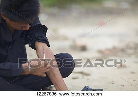 Stock Photograph - Heroin addict injects; Phnom Penh, Cambodia. Fotosearch
