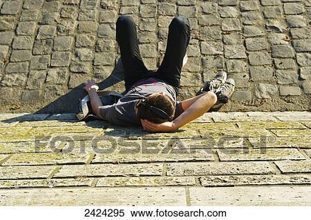 Stock Photography - High angle view of a young man sitting on a walkway against a building; Paris, France. Fotosearch