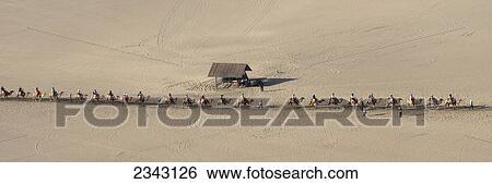 High Angle View Of People Riding Camels At Mingsha Mountain; Jiuquan, Gansu, China View Large Photo Image Stock Photograph - High Angle View Of People Riding Camels At Mingsha Mountain; Jiuquan, Gansu, China. Fotosearch