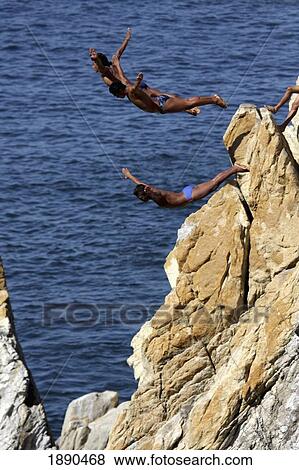 Stock Photo - High Divers Jumping From High Dive Rock. Fotosearch