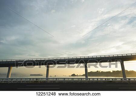 Stock Photo - Highway from Xiamen city, China at sunset, with Gulangyu island in the background; Xiamen, China. Fotosearch