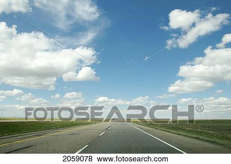 Stock Photo - Highway Surrounded By Endless Fields And Big Blue Skies, Alberta, Canada. Fotosearch