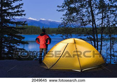 Hiker By A Tent Looking Out At Boya Lake At Dusk, Boya Lake Provincial Park, Northern British Columbia View Large Photo Image Stock Photography - Hiker By A Tent Looking Out At Boya Lake At Dusk, Boya Lake Provincial Park, Northern British Columbia. Fotosearch
