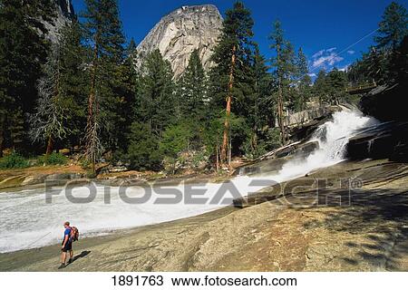 Stock Image - Hiker By River At Mount Broderick. Fotosearch