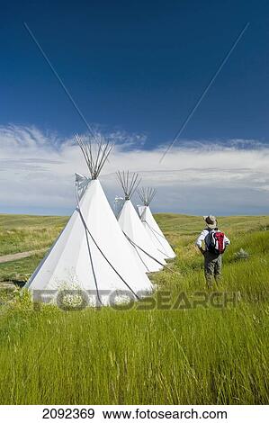 Stock Photo - Hiker Looking At Tipis In Grasslands National Park; Val Marie Saskatchewan Canada. Fotosearch