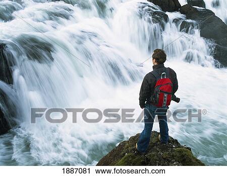 Hiker Looking Over Small Waterfall. View Large Photo Image Stock Image - Hiker Looking Over Small Waterfall.. Fotosearch