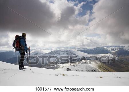 Stock Photo - Hiker Overlooking Snow Covered Newlands Valley. Fotosearch