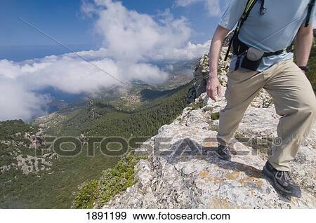 Hiker Walking Beside Cliff On Mountain Track, Low Section View Large Photo Image Stock Photo - Hiker Walking Beside Cliff On Mountain Track, Low Section. Fotosearch