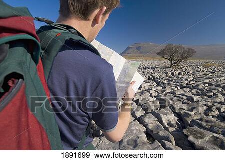 Stock Photo - Hiker With Map On Limestone Pavement. Fotosearch