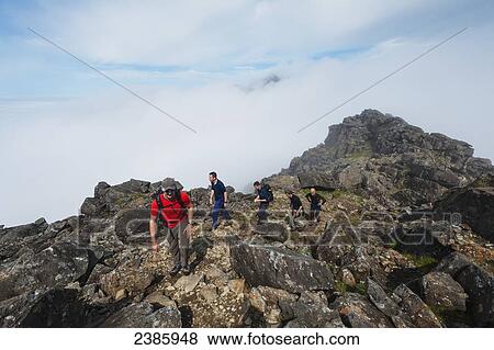Hikers emerging above clouds near the top of Sgurr nan Eag, one of the peaks in the Black Cuillin; Isle of Skye, Scotland View Large Photo Image Stock Photo - Hikers emerging above clouds near the top of Sgurr nan Eag, one of the peaks in the Black Cuillin; Isle of Skye, Scotland. Fotosearch