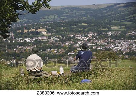 Stock Photograph - Hikers having a picnic lunch rest on the famous National Trail 100 mile Cotswold Way trail above Cheltenham; Gloucestershire, England. Fotosearch