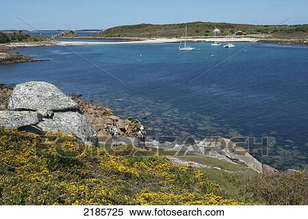 Hikers On The Coastal Path Around St Agnes With The Island Of Gugh And The Sand Bar In The Distance, Isles Of Scilly, Cornwall, Uk, Europe View Large Photo Image Stock Photography - Hikers On The Coastal Path Around St Agnes With The Island Of Gugh And The Sand Bar In The Distance, Isles Of Scilly, Cornwall, Uk, Europe. Fotosearch
