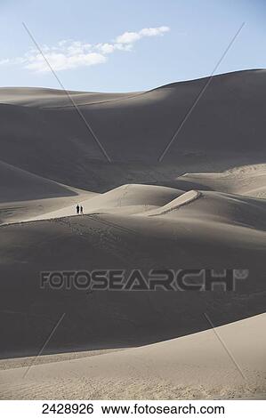 Stock Photograph - Hikers on the sand dunes of Great Sand Dunes National Park and Preserve; Colorado, United States of America. Fotosearch