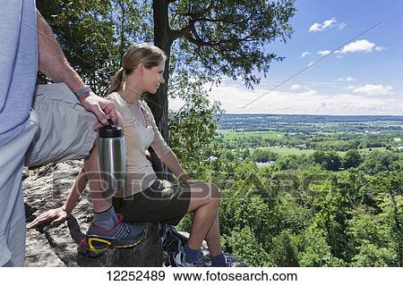 Stock Photo - Hikers taking a break at Rattlesnake Point; Milton, Ontario. Fotosearch