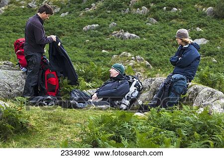 Hikers Taking Break From Walking Among Hills Of Western Lake District; Cumbria, England, Uk View Large Photo Image Stock Image - Hikers Taking Break From Walking Among Hills Of Western Lake District; Cumbria, England, Uk. Fotosearch
