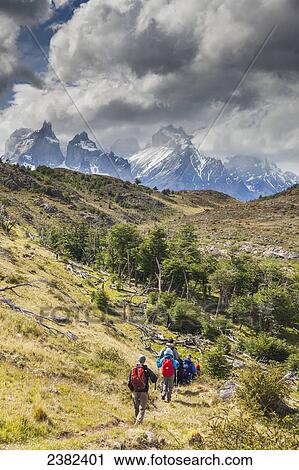 Stock Image - Hikers walk along a trail in the Torres del Paine National Park; Patagonia, Chile. Fotosearch