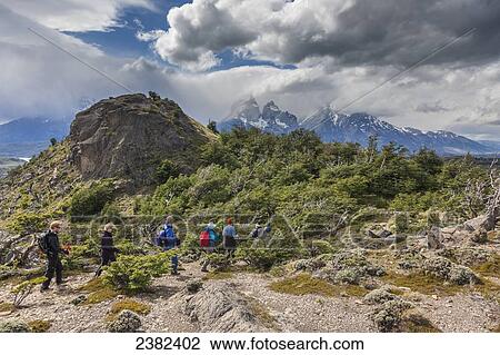 Stock Image - Hikers walk along a trail in the Torres del Paine National Park; Patagonia, Chile. Fotosearch