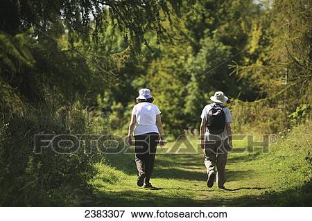 Stock Photo - Hikers walking on the famous National Trail 100 mile Cotswold Way trail above Cheltenham; Gloucestershire, England. Fotosearch