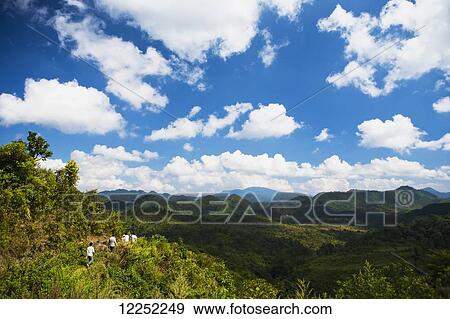 Hiking on a trail through lush foliage with a mountainous landscape in the distance; Hintang, Laos View Large Photo Image Stock Photo - Hiking on a trail through lush foliage with a mountainous landscape in the distance; Hintang, Laos. Fotosearch